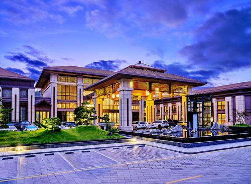 a large house with cars parked in front of it at Regal Palace DeRUCCI Resort in Huizhou