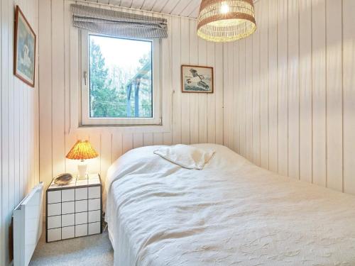 a bedroom with a white bed and a window at Holiday home Aakirkeby XLIV in Vester Sømarken
