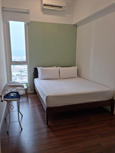 a bed in a room with two large windows at Una Residence by Maya in Kuala Lumpur