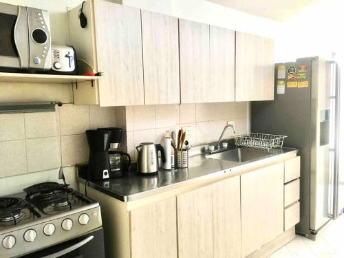 een kleine keuken met een fornuis en een wastafel bij Apartamento de 4 Habitaciones Éxito de Laureles in Medellín