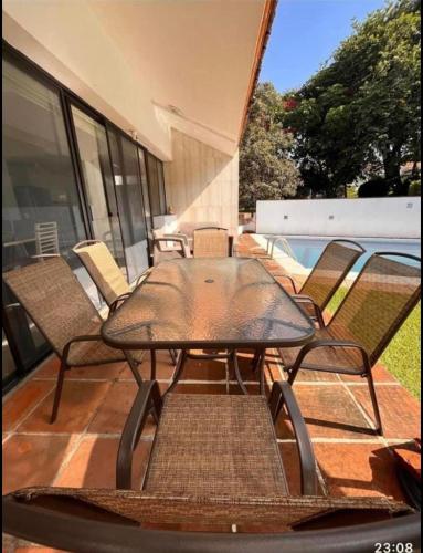 patio ze stołem i krzesłami oraz basenem w obiekcie Casa Lomas w mieście Tula de Allende