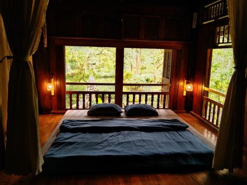 uma cama grande num quarto com duas almofadas em Mận Homestay - Lục Yên Homestay and Tour 