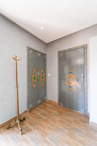 a room with two doors with paintings on the walls at Riad Les Nuits De Fès in Fès