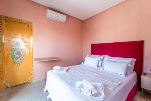 a bedroom with a large bed with a red headboard at Riad Les Nuits De Fès in Fès