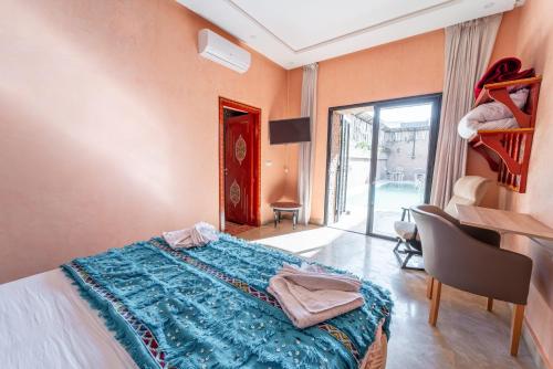 a bedroom with a bed with a blue blanket on it at Riad Les Nuits De Fès in Fès