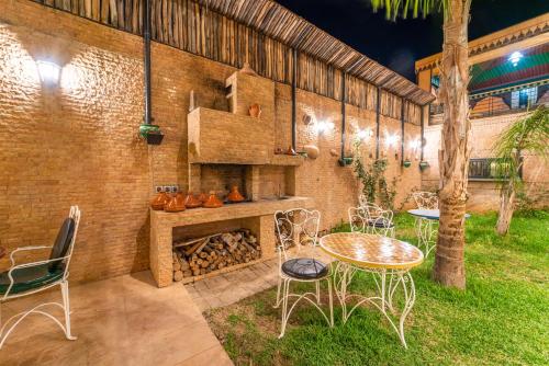 a patio with a table and chairs and a fireplace at Riad Les Nuits De Fès in Fès