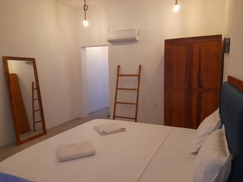 a room with a bed with a mirror and a ladder at Surf Gangs Arugambay in Arugam Bay
