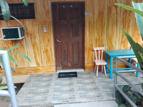 um quarto com uma porta de madeira, uma mesa e uma secretária em Woodland Inn em El Nido