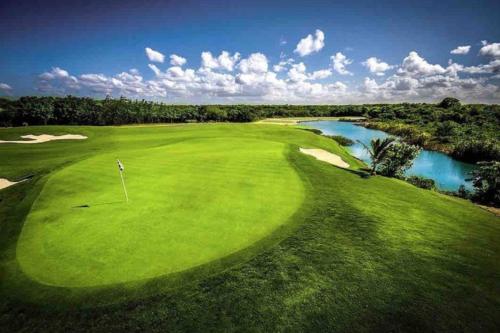 an overhead view of a golf course with a river at Cana Rock Star luxury condo, Casino, golf, beach in Hard Rock área in Punta Cana