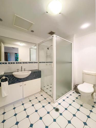 a bathroom with a shower and a toilet and a sink at Trinity Links Resort in Cairns
