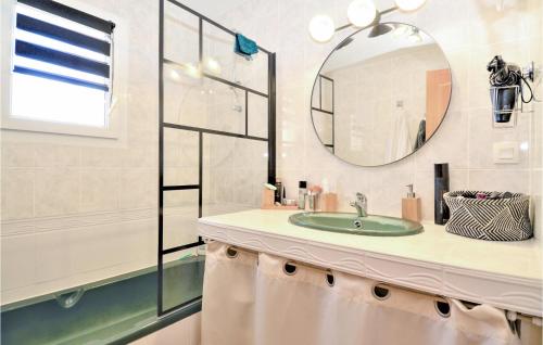 een badkamer met een wastafel en een spiegel bij Cozy Home In St Genies De Malgoires With Ethernet Internet in Saint-Géniès-de-Malgoirès