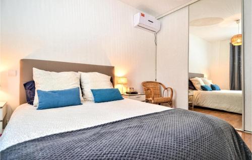 een slaapkamer met een groot bed met blauwe kussens bij Cozy Home In St Genies De Malgoires With Ethernet Internet in Saint-Géniès-de-Malgoirès