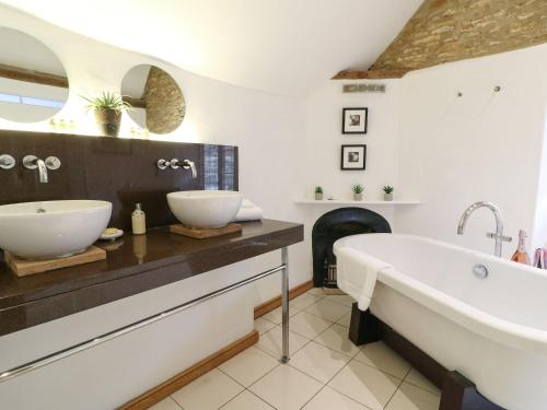 baño con bañera grande y lavamanos en Castle Combe Cottage, en Castle Combe