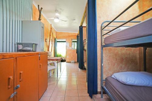 a room with two bunk beds and a kitchen at Woolshed Eco Lodge in Hervey Bay