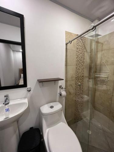 a bathroom with a toilet and a sink and a shower at Katara Boutique Hotel in Mariquita