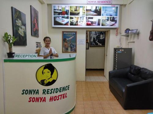 una mujer de pie detrás de un mostrador en una habitación en Sonya Residence, en Patong Beach