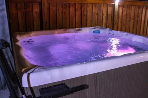 a purple jacuzzi tub in a wooden wall at Family Friendly - Cozy - HOT TUB - Near UOIT in Oshawa