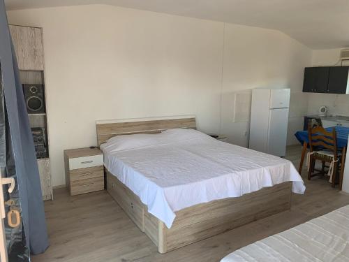 Schlafzimmer mit einem Bett, einem Tisch und einem Kühlschrank in der Unterkunft Apartments Lado - 230 m from sea in Donje Selo