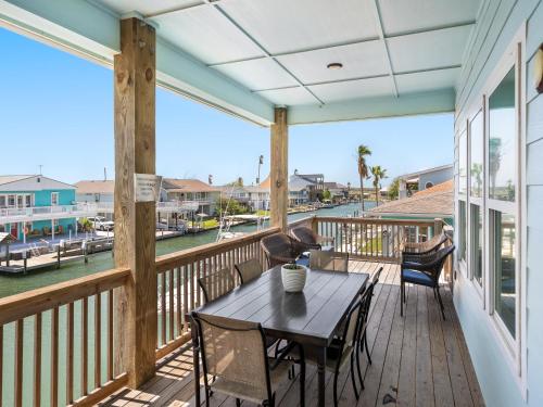 a porch with a table and chairs and a view of the water at Port Royal Dream in City-by-the Sea