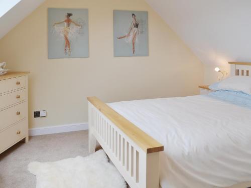 a bedroom with a bed and two pictures on the wall at Dairy Cottage in Matfield