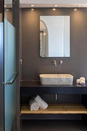 a bathroom with a sink and a mirror and towels at GL Villa in Agios Romanos