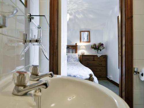 a bathroom with a sink and a bed in a room at Wheelhousee - Hmq in Combe Martin