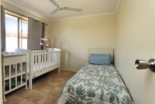 a baby room with a crib and a baby crib at 13 Natalie Street Bargara in Bargara