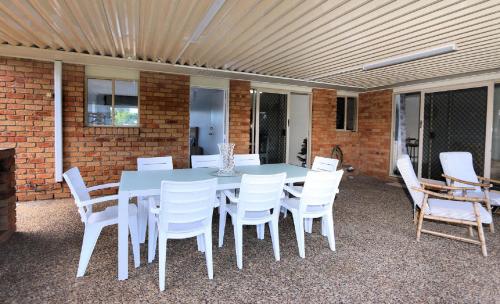 a white table and chairs on a patio at 13 Natalie Street Bargara in Bargara