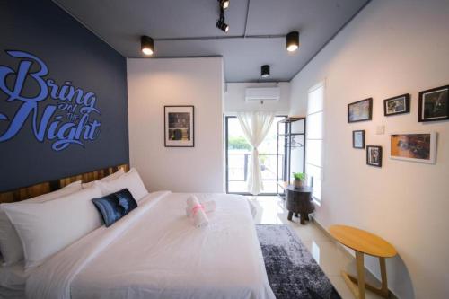 um quarto com uma cama branca e uma placa na parede em Pondok Tok Bee em Bayan Lepas