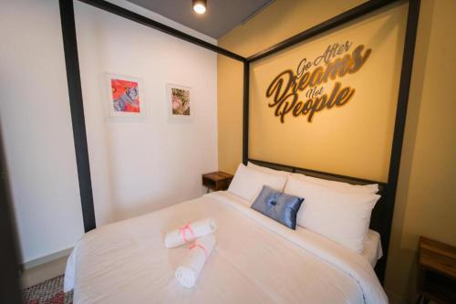 1 dormitorio con 1 cama blanca y un cartel en la pared en Pondok Tok Bee, en Bayan Lepas