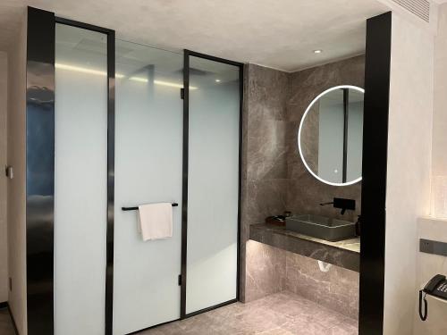 a bathroom with a mirror and a sink at Dream Designer Hotel - Huimin Street Branch of Xi'an Bell and Drum Tower in Xi'an
