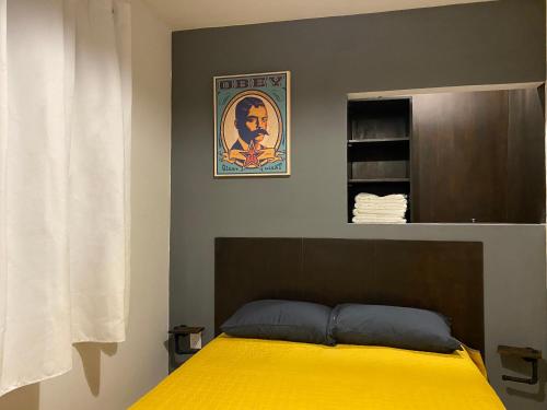 a bedroom with a bed with a yellow blanket at Cozy Condesa in Mexico City