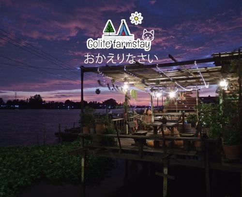 a restaurant with a lit up sign at night at Baan GoLite Ko Kret - บ้านโกไล้เกาะเกร็ด in Nonthaburi