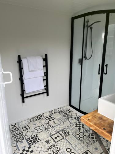 a bathroom with a shower and a tile floor at Central Matamata Boutique in Matamata