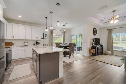 a large kitchen with white cabinets and a large island at Family Villa King Bed, 3 bedrooms 2baths, 7 guests, Close to Beaches, Golfing, Fishing in Rotunda-West