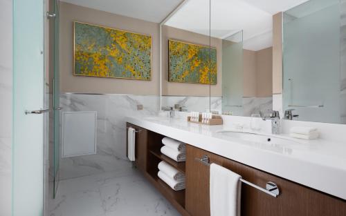 a bathroom with a sink and a shower and a mirror at Swissôtel Wellness Resort Alatau Almaty in Almaty