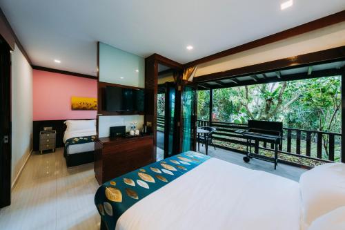a bedroom with a bed and a balcony with a piano at Kranji Sanctuary Resort in Singapore