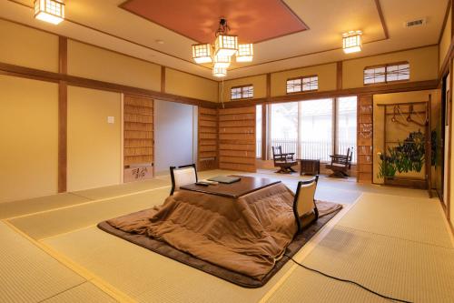 a room with a bed with a blanket on the floor at Kadojin in Tenkawa