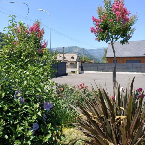 a garden with pink flowers in a parking lot at Le balcon des cimes in Adast