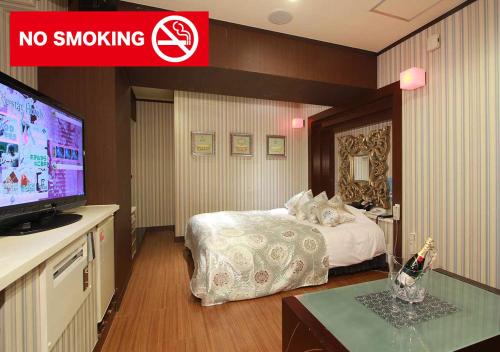 a hotel room with a bed and a no smoking sign at Restay Mito (Adult Only) in Mito
