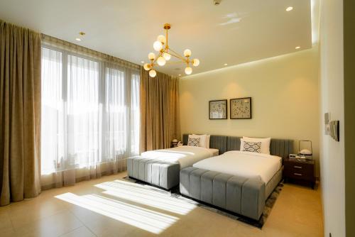 a bedroom with two beds and a chandelier at Damask Resort in Jabal Al Akhdar