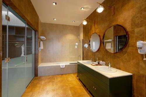 a bathroom with a sink and a shower and a tub at Damask Resort in Jabal Al Akhdar