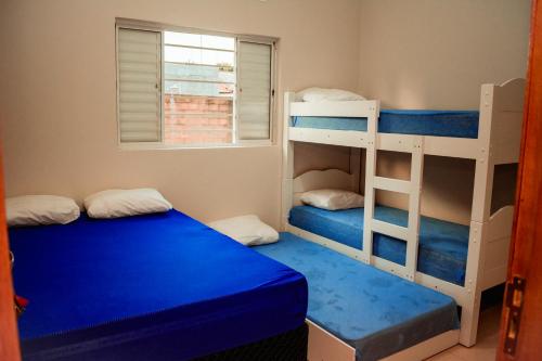 a bedroom with two bunk beds and a window at Chacara Las Palomas in Presidente Epitácio