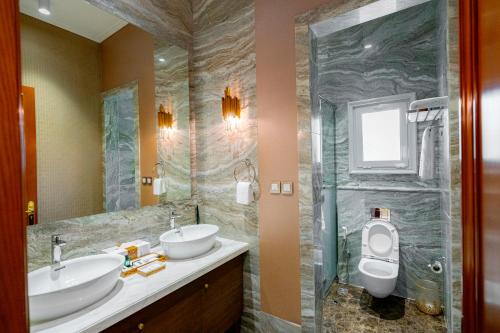 a bathroom with two sinks and a toilet at Damask Resort in Jabal Al Akhdar