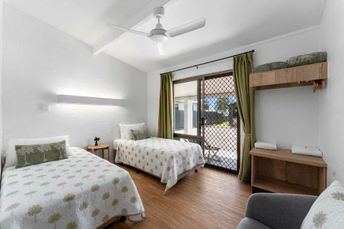 a bedroom with two beds and a balcony at Kinka Palms Motel in Kinka