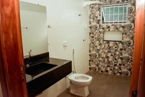 a bathroom with a toilet and a sink at Chacara Las Palomas in Presidente Epitácio