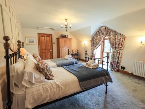 a bedroom with two beds and a window at The Stables in Ambleside