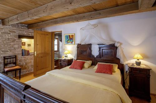 a bedroom with a large bed with two red pillows at Una in Kranjčići - Haus für 5-6 Personen in Svetvinčenat