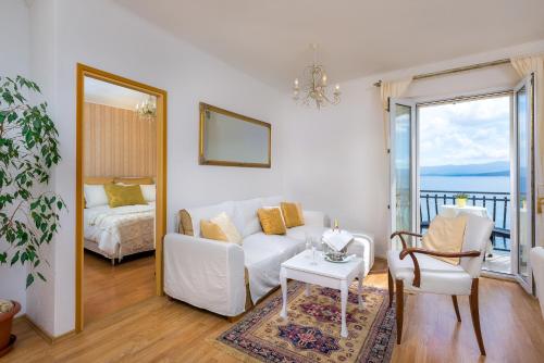 ein Wohnzimmer mit einem weißen Sofa und einem Bett in der Unterkunft Apartments Santo in Bol