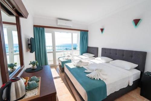 1 Schlafzimmer mit 2 großen Betten und einem Balkon in der Unterkunft SAFAK OTEL DIDIM in Didim